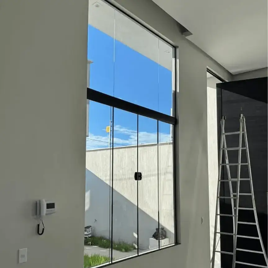 Janela em vidro temperado com pé-direito alto instalada em residência moderna em Rio das Ostras
